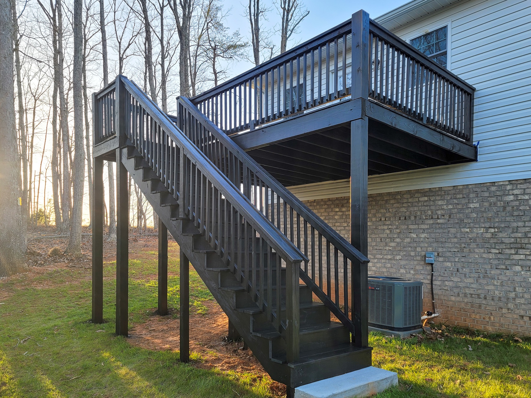 Elevated deck, stairs, railings, and supports finished in a dark charcoal coating