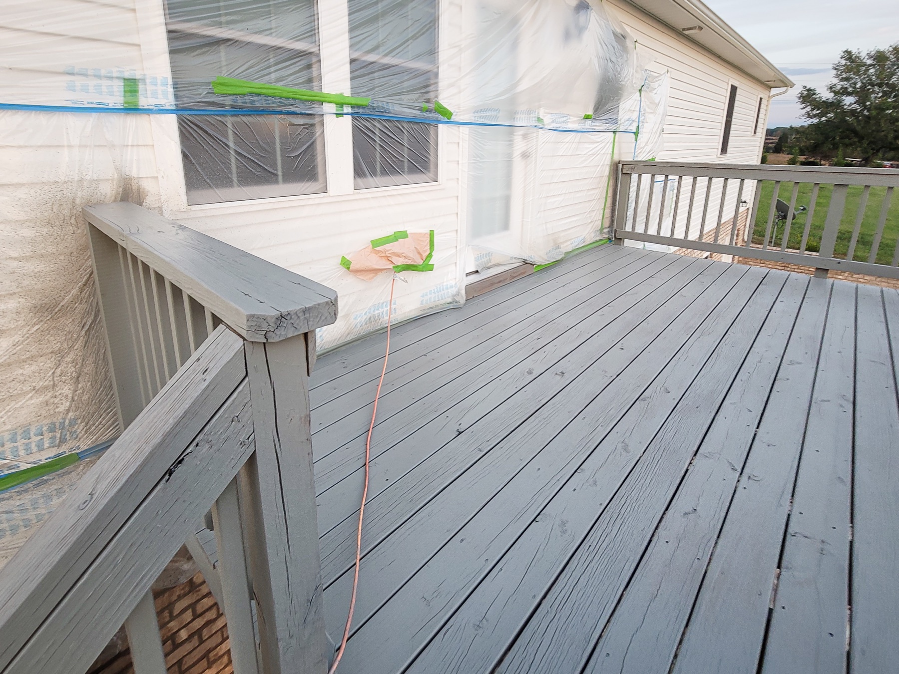 Exterior deck and home carefully masked during a gray painting project
