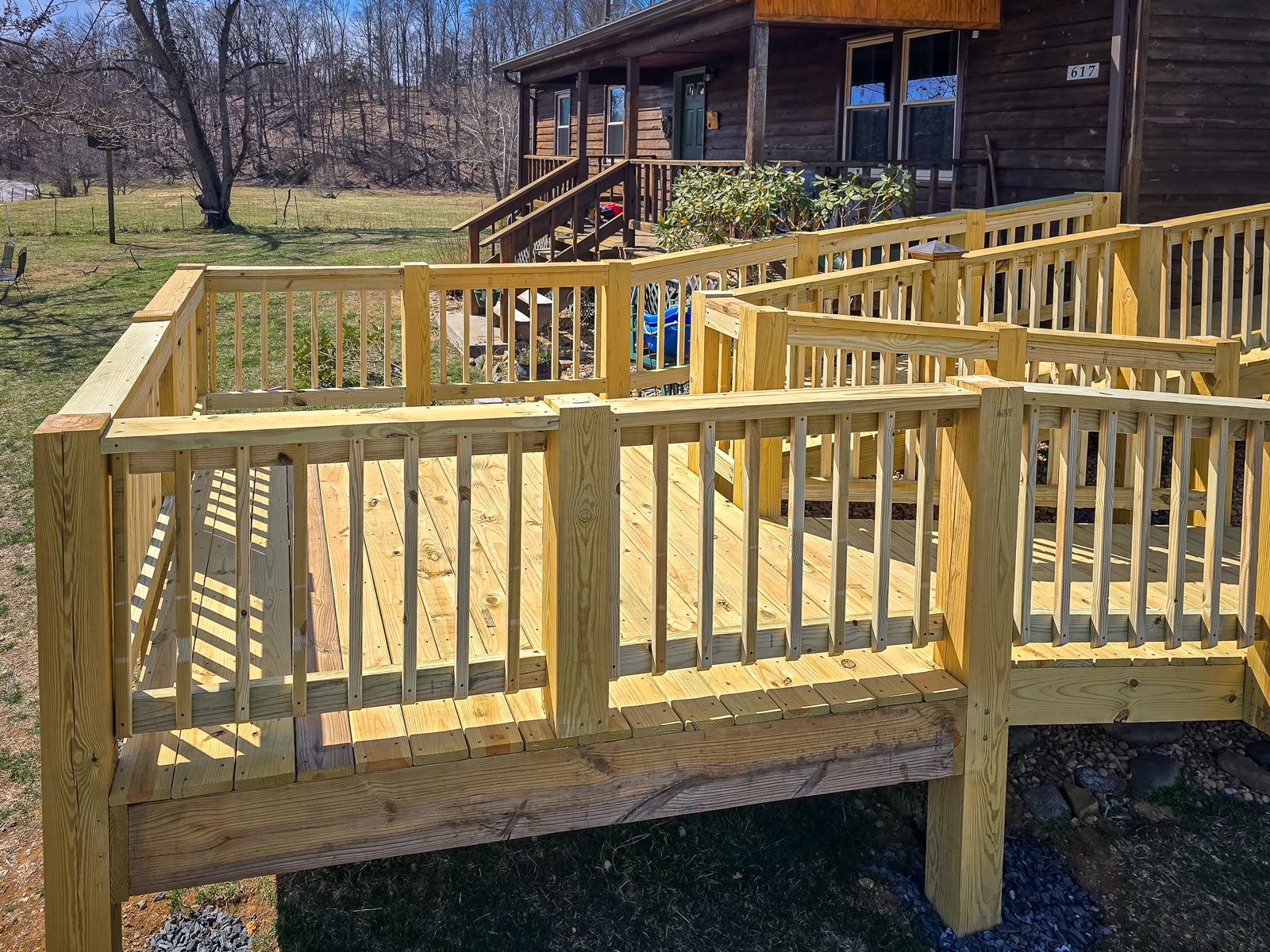 Multi-level wood access ramp with switchback railings beside a home